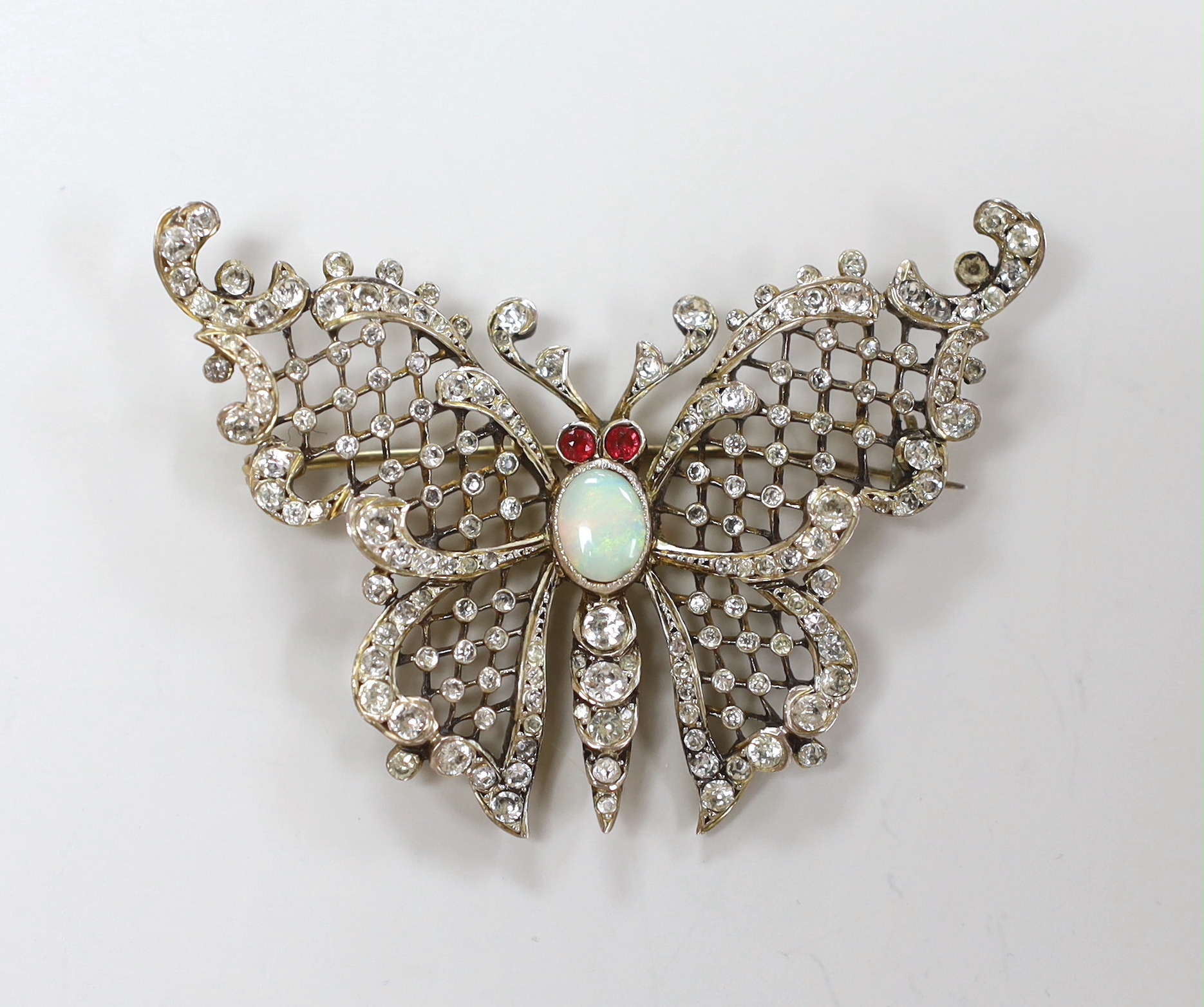 A late 19th/early 20th gilt white metal, white opal and two colour paste set butterfly brooch, width 59mm.